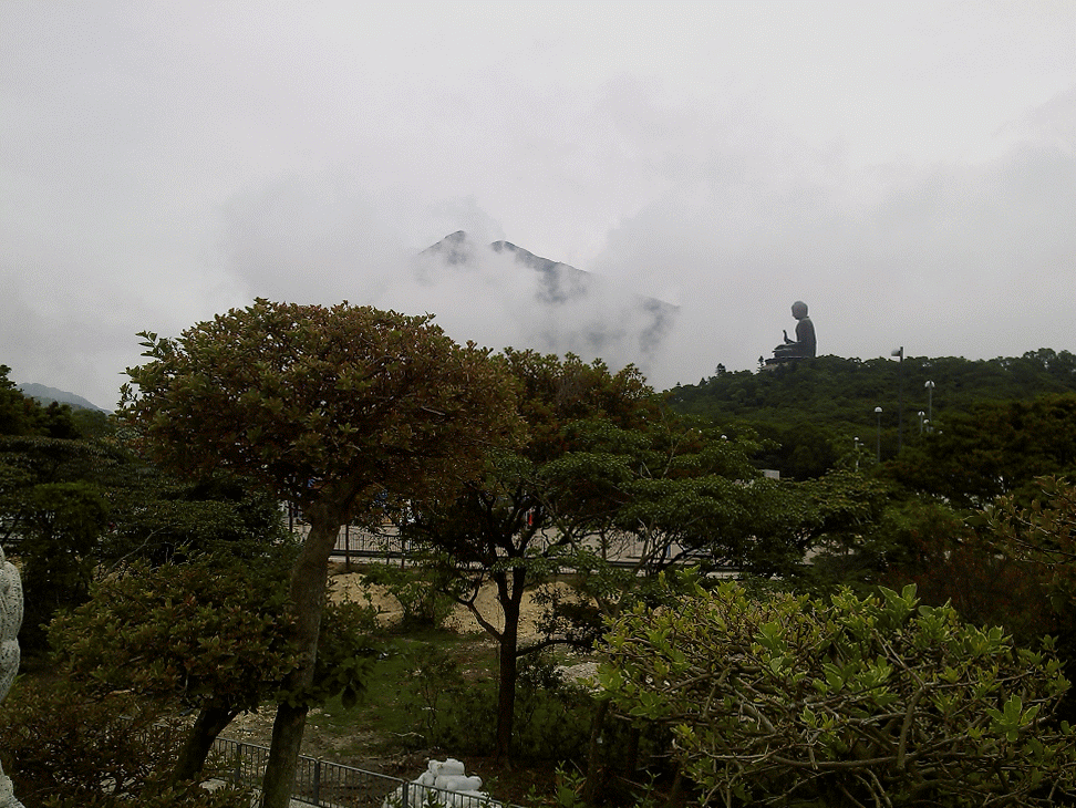 Tian Tan Buddha is in clouds but visible from afar, Hong Kong